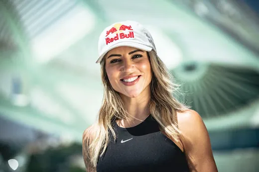 Leticia Bufoni sorrindo, de boné Red Bull